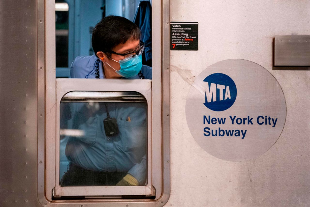 A New York City Mass Transit Authority (MTA) transit worker looks down the platform from a subway car after arriving at the Coney Island station in Brooklyn, New York on May 6.