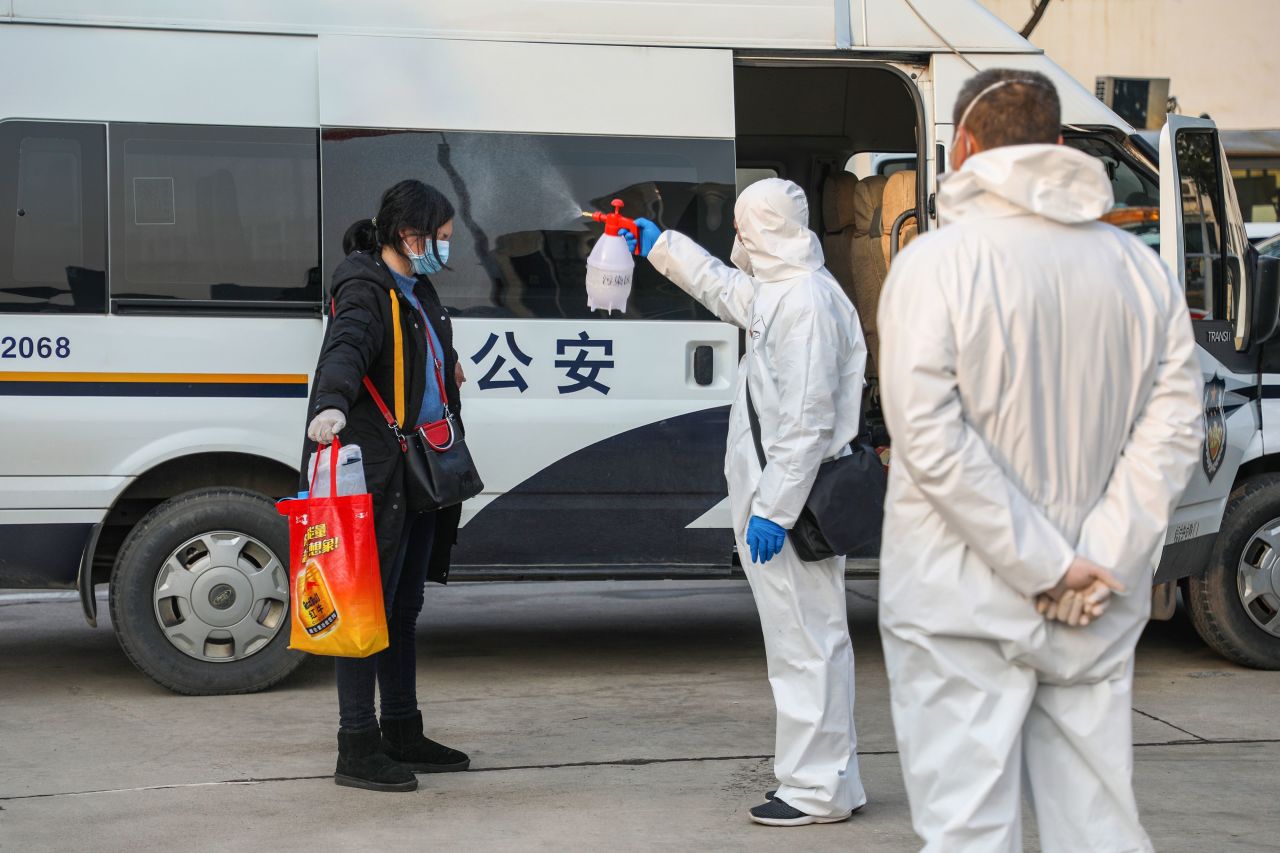 This photo taken on February 3, 2020 shows a medical staff member spraying disinfectant on a patient after returning from a hospital and re-entering a quarantine zone in Wuhan. STR/AFP via Getty Images)