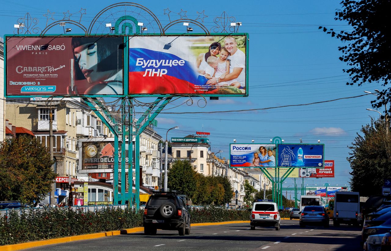 Vehicles drive past advertising boards, including panels displaying pro-Russian slogans, in a street in the course of Russia-Ukraine conflict in?Luhansk, Ukraine on September 20.