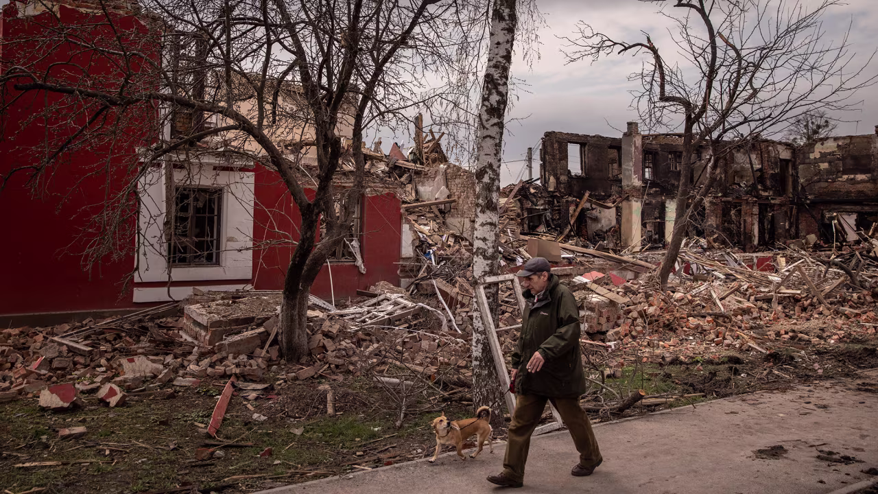 A man walks his dog past a building destroyed by recent Russian shelling in Kharkiv, Ukraine on April 14.