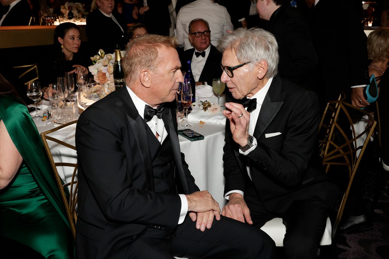 Kevin Costner and Harrison Ford chat in the crowd. 