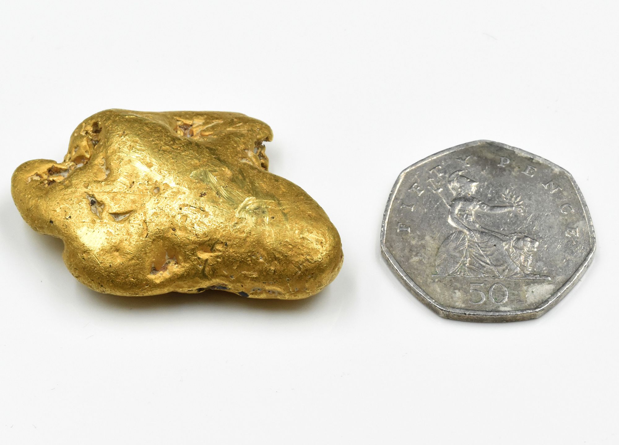 The gold nugget, shown next to a UK 50 pence coin for size.