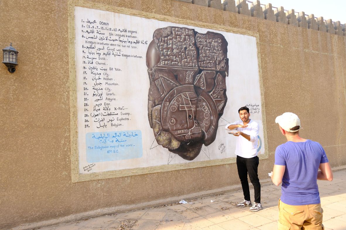 <strong>Map of the world: </strong>Hussien Hashim makes a living taking tourists around the Babylon site. Here he shows a Babylonian map of the world to Italian tourist Gianmaria Vergani.