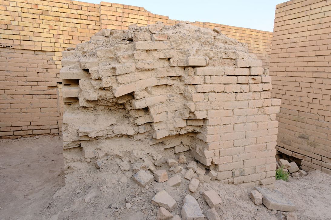 An exposed ancient brick surrounded by loose soil and debris. On the Babylonian website.