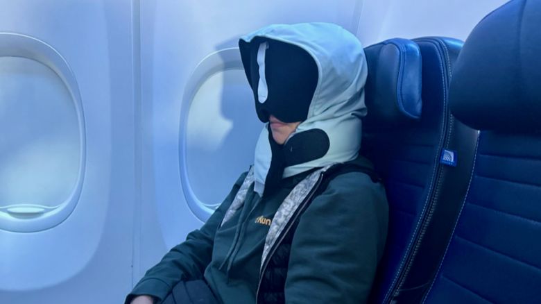 A photo of a person wearing the Pod Travel Pillow on an airplane