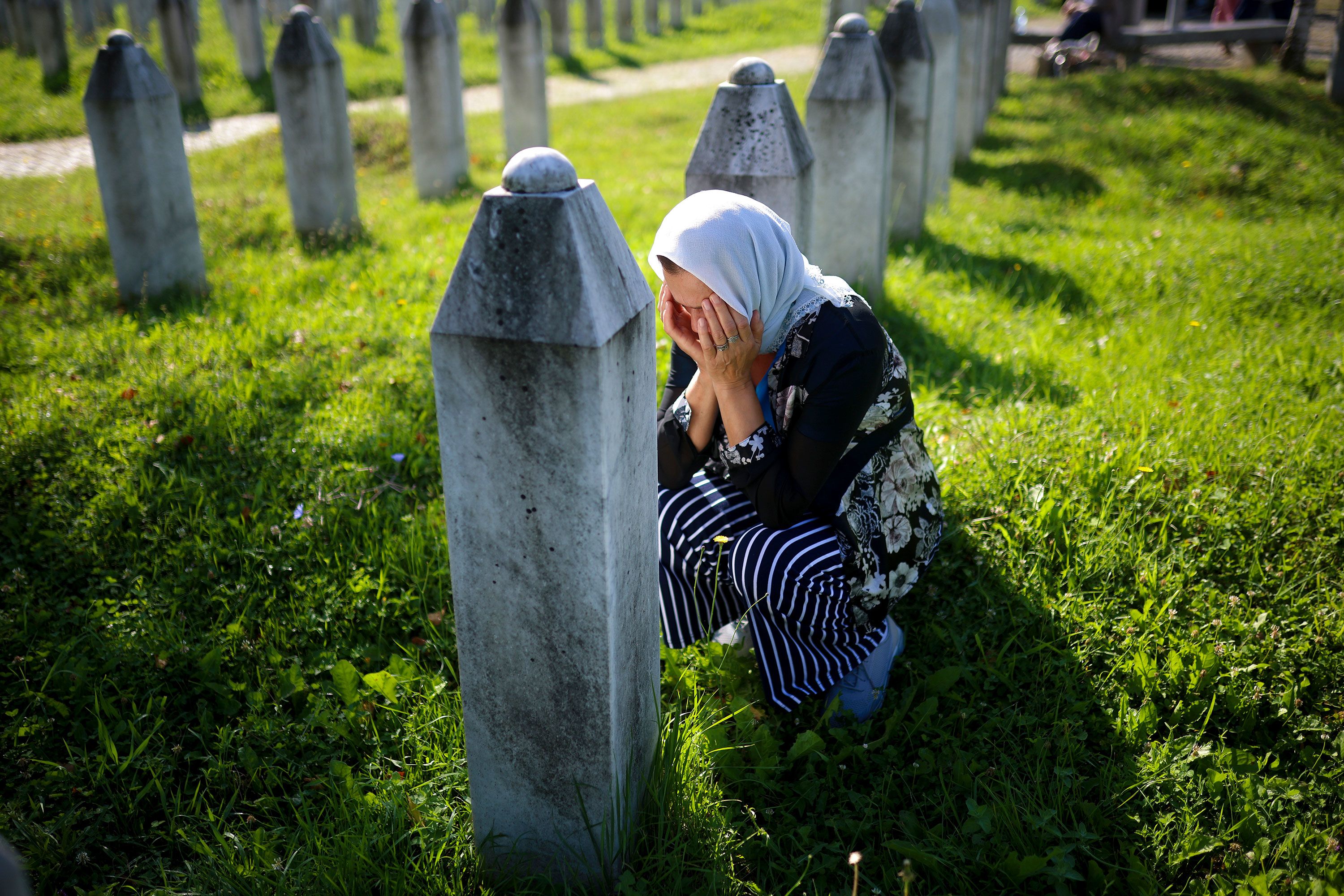 A woman in Potočari, Bosnia-Herzegovina, mourns Thursday, July 11, next to the grave of a relative who was killed in the <a href="https://www.cnn.com/2017/11/22/opinions/amanpour-srebrenica-memories/index.html">Srebrenica genocide</a> 29 years ago.