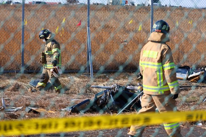 Firefighters search through the debris at the site of the crash.