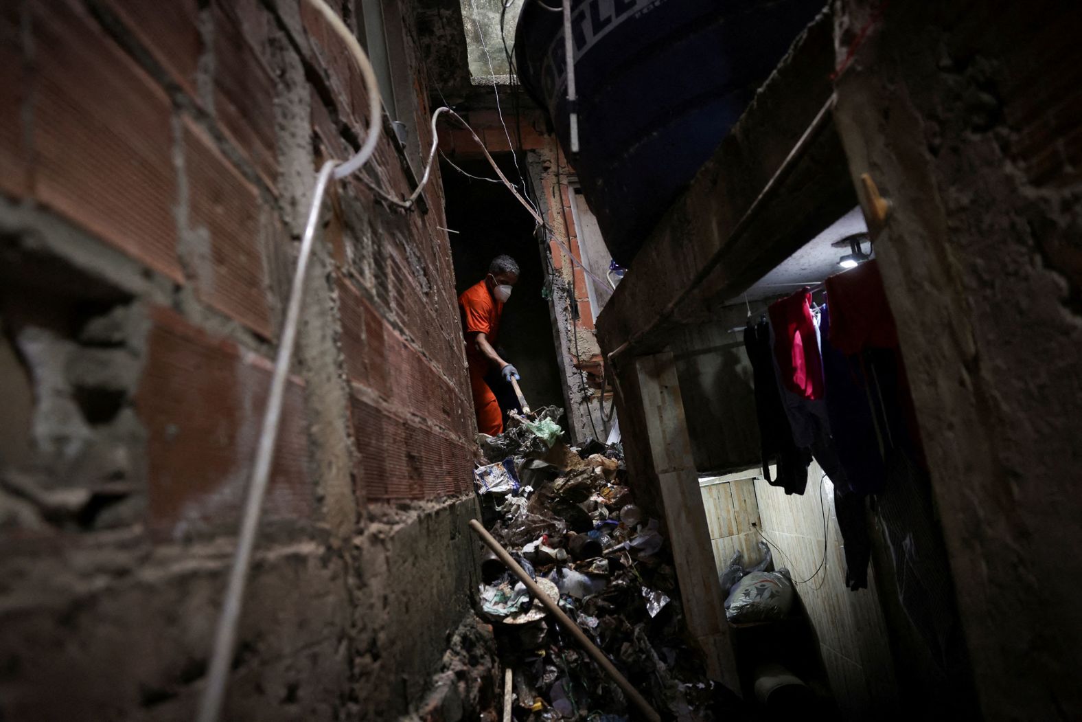 A person collects garbage from a house in the Rocinha slum of Rio de Janeiro on Wednesday, February 7. There had been complaints from residents about potential breeding sites for the Aedes aegypti mosquito, which is responsible for spreading dengue fever, Zika, chikungunya and yellow fever. Just days before Carnival celebrations are set to take place across Brazil, <a href="index.php?page=&url=https%3A%2F%2Fwww.cnn.com%2F2024%2F02%2F07%2Famericas%2Frio-dengue-emergency-carnival-intl%2Findex.html">Rio declared a state of public health emergency</a> due to an epidemic of dengue fever.