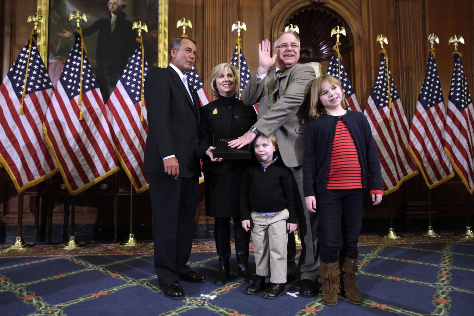 Shortly after winning a third term, Walz appears with his wife, Gwen, and their children, Hope and Gus, at a mock swearing-in ceremony with House Speaker John Boehner in 2011.