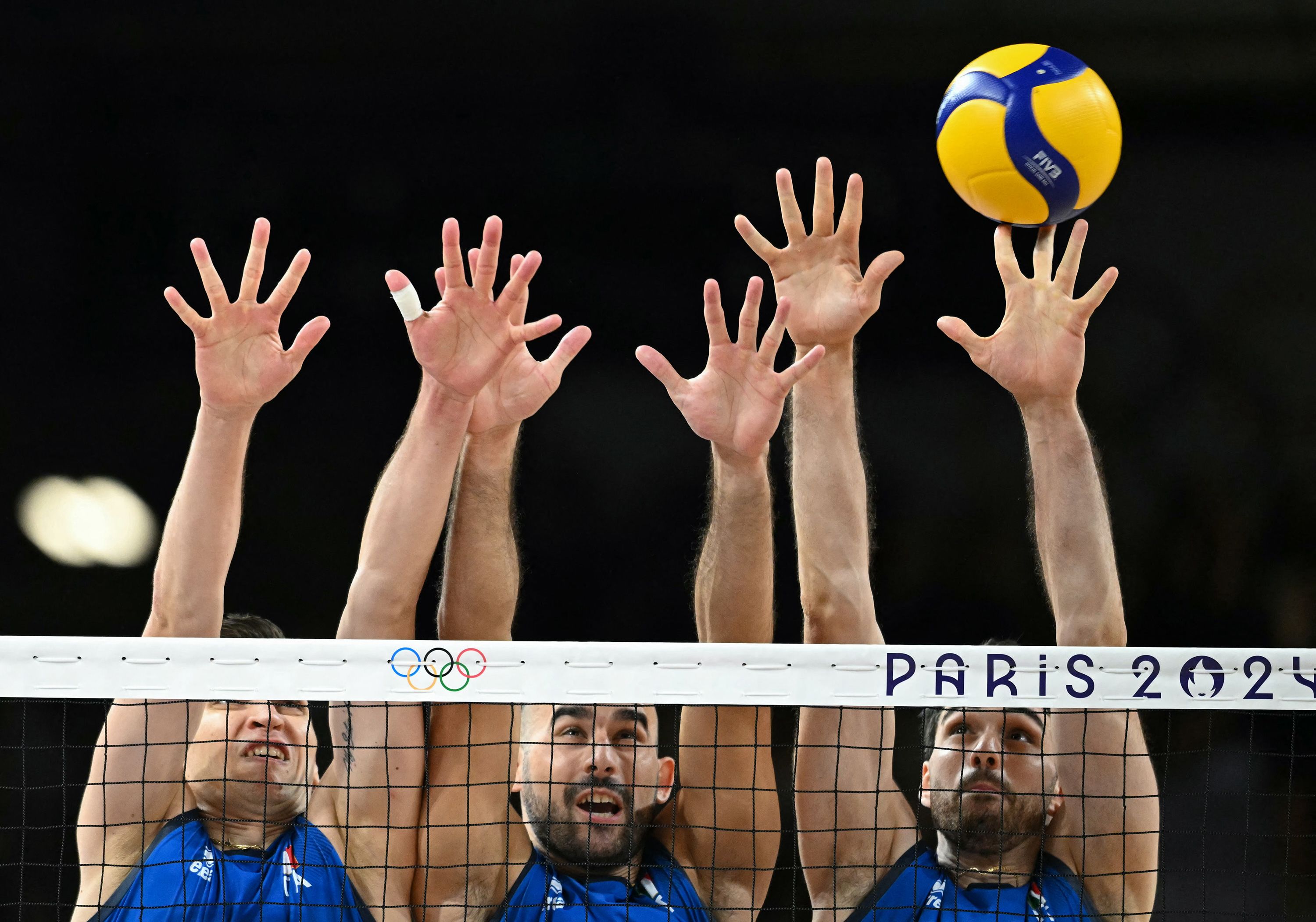 From left, Italy's Yuri Romanò, Gianluca Galassi and Daniele Lavia jump to block the ball during a volleyball match against Poland on August 3.