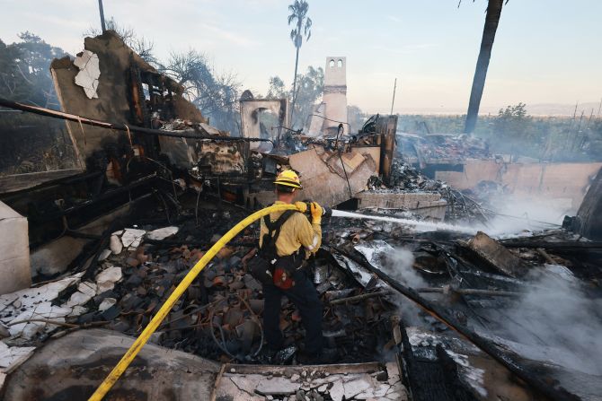 Firefighters extinguish smoldering embers as the Edgehill Fire destroys several homes and vehicles in San Bernardino, California, on August 5, 2024.