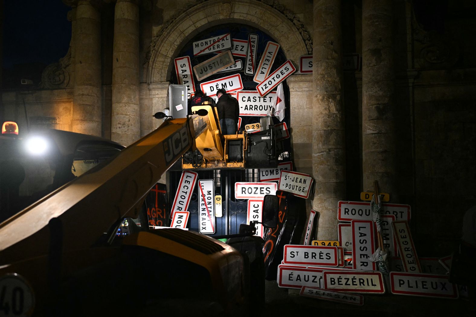 Protesters leave signs of town names on the doors of a government building in Auch, France, on Monday, November 18. French farmers have been protesting against a trade deal between the European Union and the South American countries in Mercosur, an economic and political bloc.