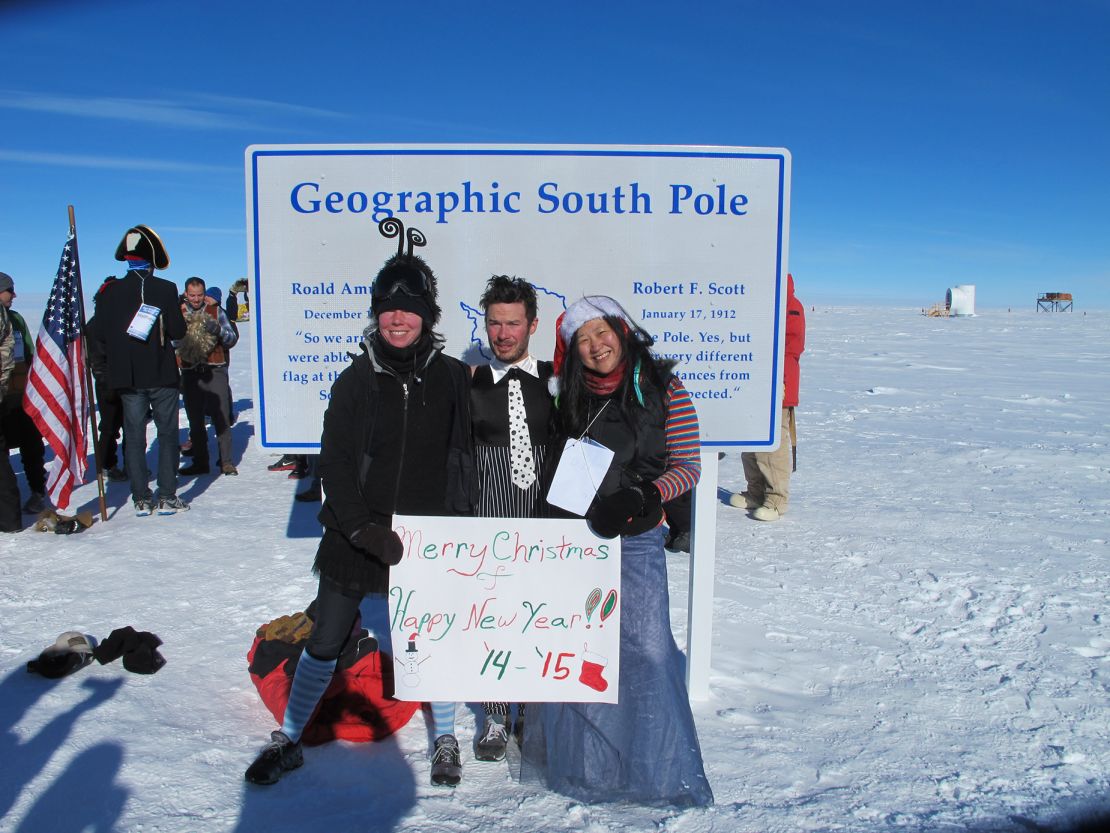 Keri Nelson and friends stand at the Geographic South Pole marker at Amundsen-Scott South Pole Station.
