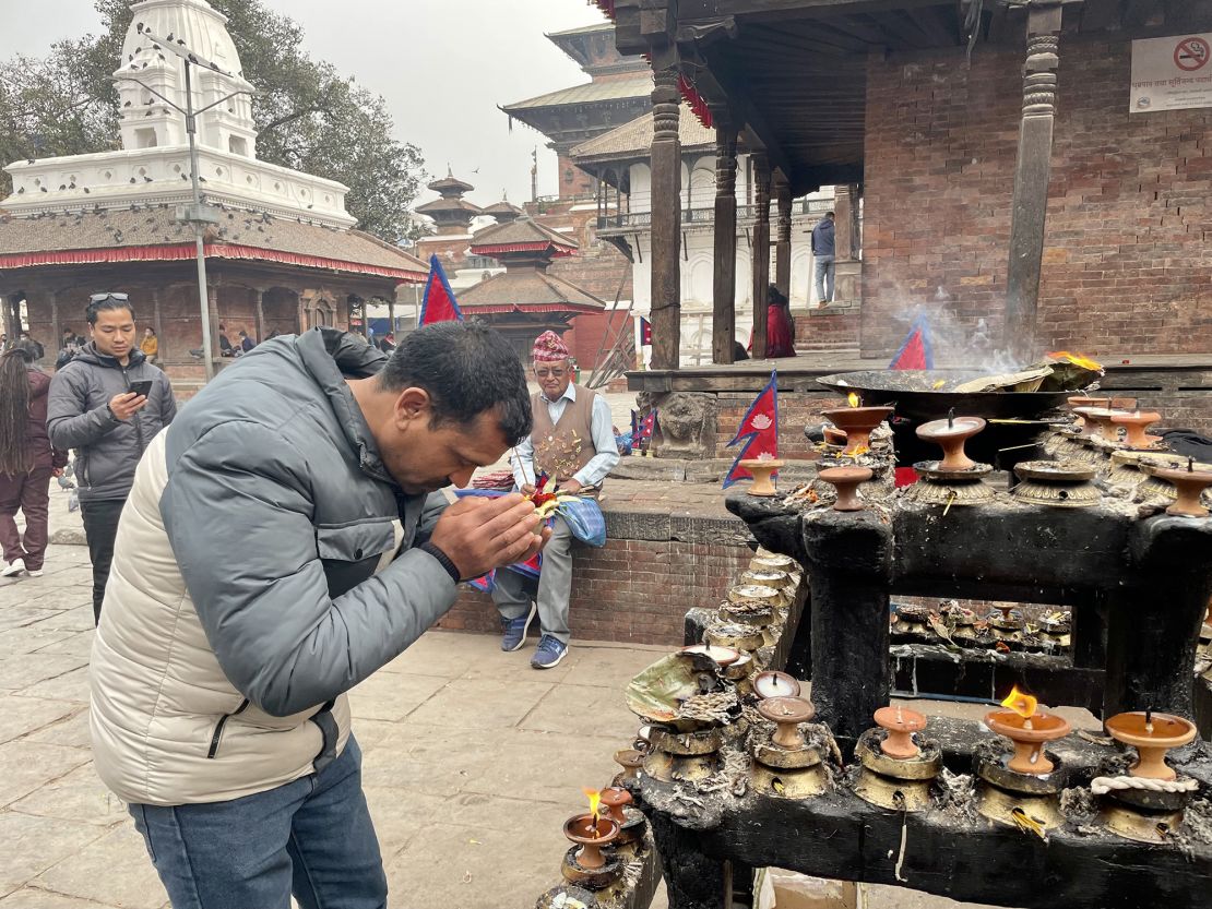 Ramchandra Khadka prays outside a temple in Kathmandu for his comrades fighting for Russia.