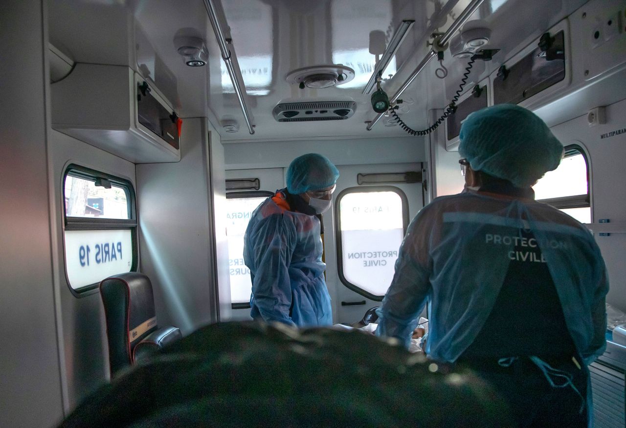 Health workers Cyril Lamriben, left, and Noemie Biamba take care of a 51-year-old woman suspected of having coronavirus in Paris, France, on Saturday, March 28.