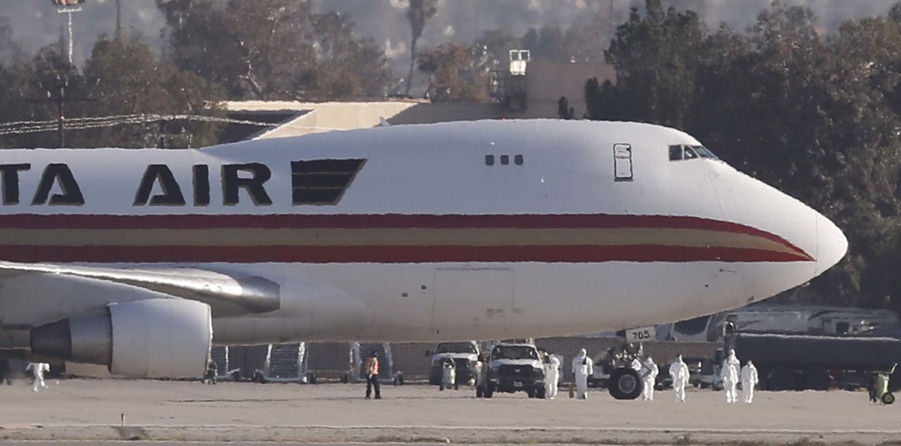 People in hazmat suits are seen outside the Kalitta Air freighter plane that has landed at March Air Reserve Base in Riverside, California on Wednesday, carrying about 200 Americans who were evacuated from Wuhan, China.