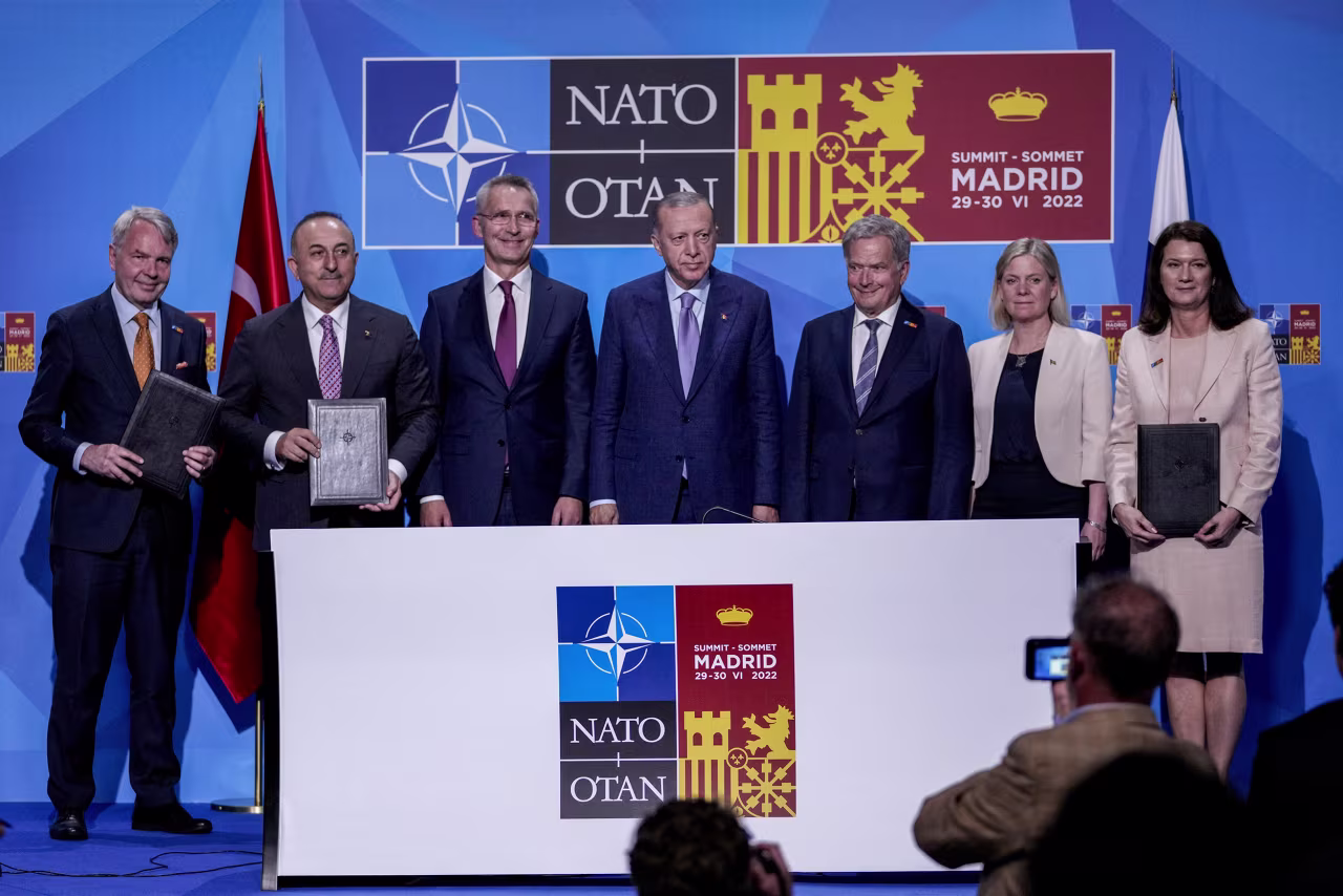 From left to right background: Finnish Foreign Minister Pekka Haavisto, Turkish Foreign Minister Mevlut Cavusoglu, NATO Secretary General Jens Stoltenberg, Turkish President Recep Tayyip Erdogan, Finland's President Sauli Niinisto, Sweden's Prime Minister Magdalena Andersson, and Sweden's Foreign Minister Ann Linde pose for a picture after signing a memorandum in which Turkey agrees to Finland and Sweden's membership of the defense alliance in Madrid, Spain, on June 28