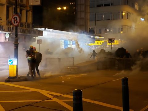 Riot police fire tear gas at protesters in Kowloon.