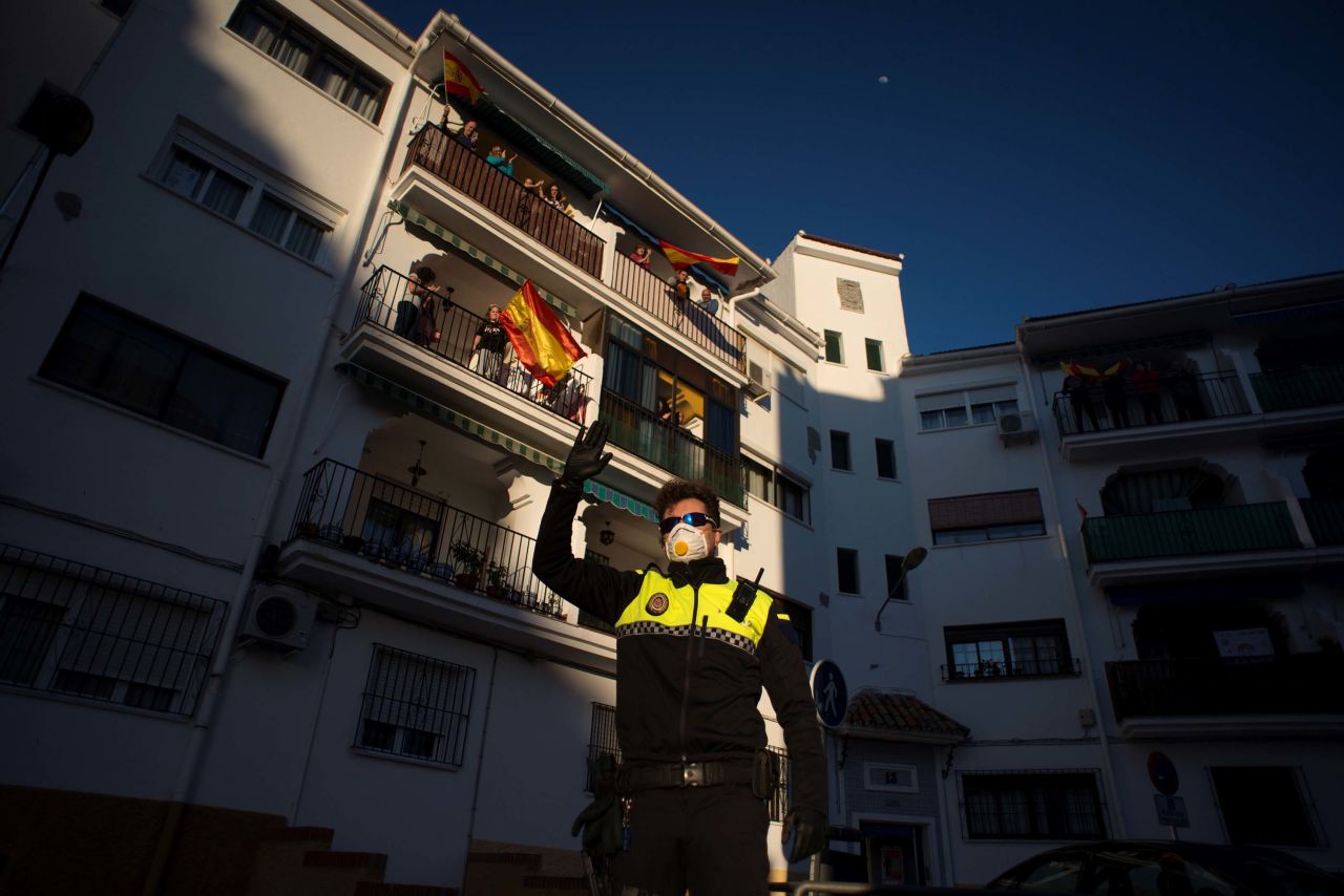 A police officer waves as people applaud to thank healthcare workers dealing with the coronavirus outbreak in Ronda, Spain, on April 3.