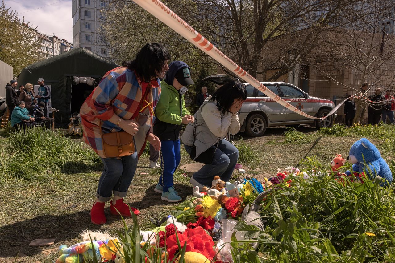 People gather next to a memorial for victims of a Russian attack in Uman, Ukraine, on April 29. 