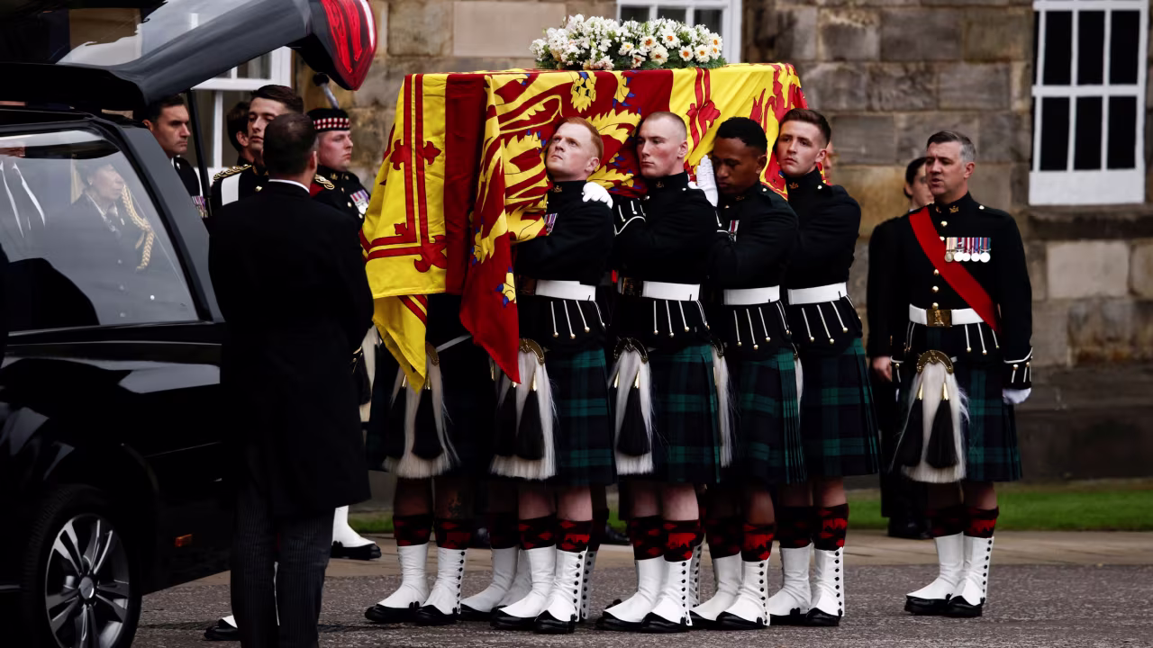 The coffin is carried from the hearse.