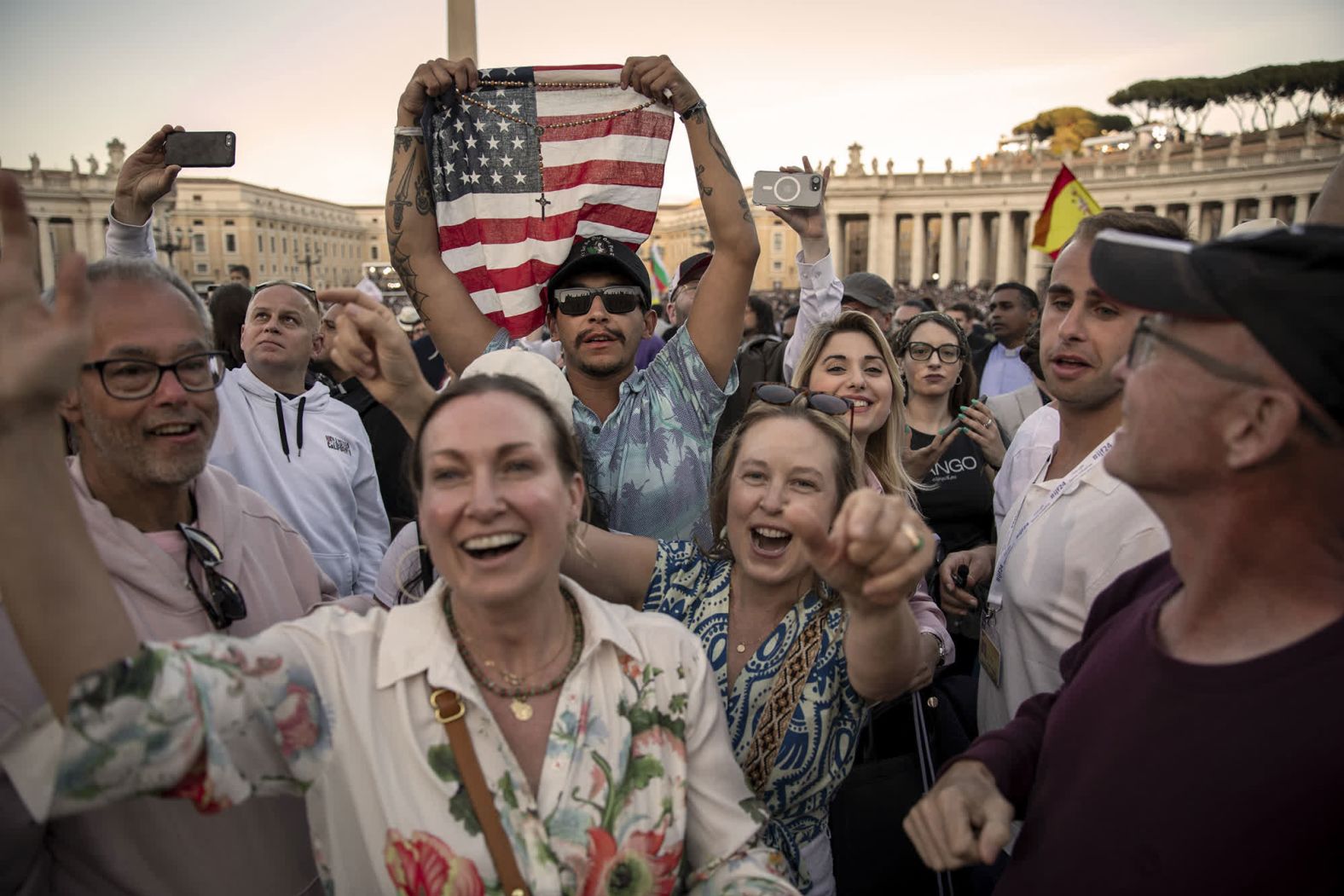 A man in St. Peter’s Square holds up an American flag as people cheer for the new pope at the Vatican on Thursday, May 8.