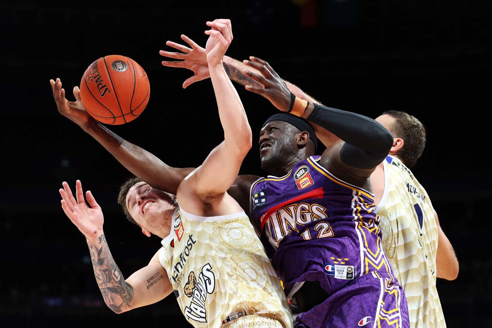 Kouat Noi of the Kings, center, competes for the ball during an NBL game against the Taipans in Sydney, Australia, on Sunday, September 28.