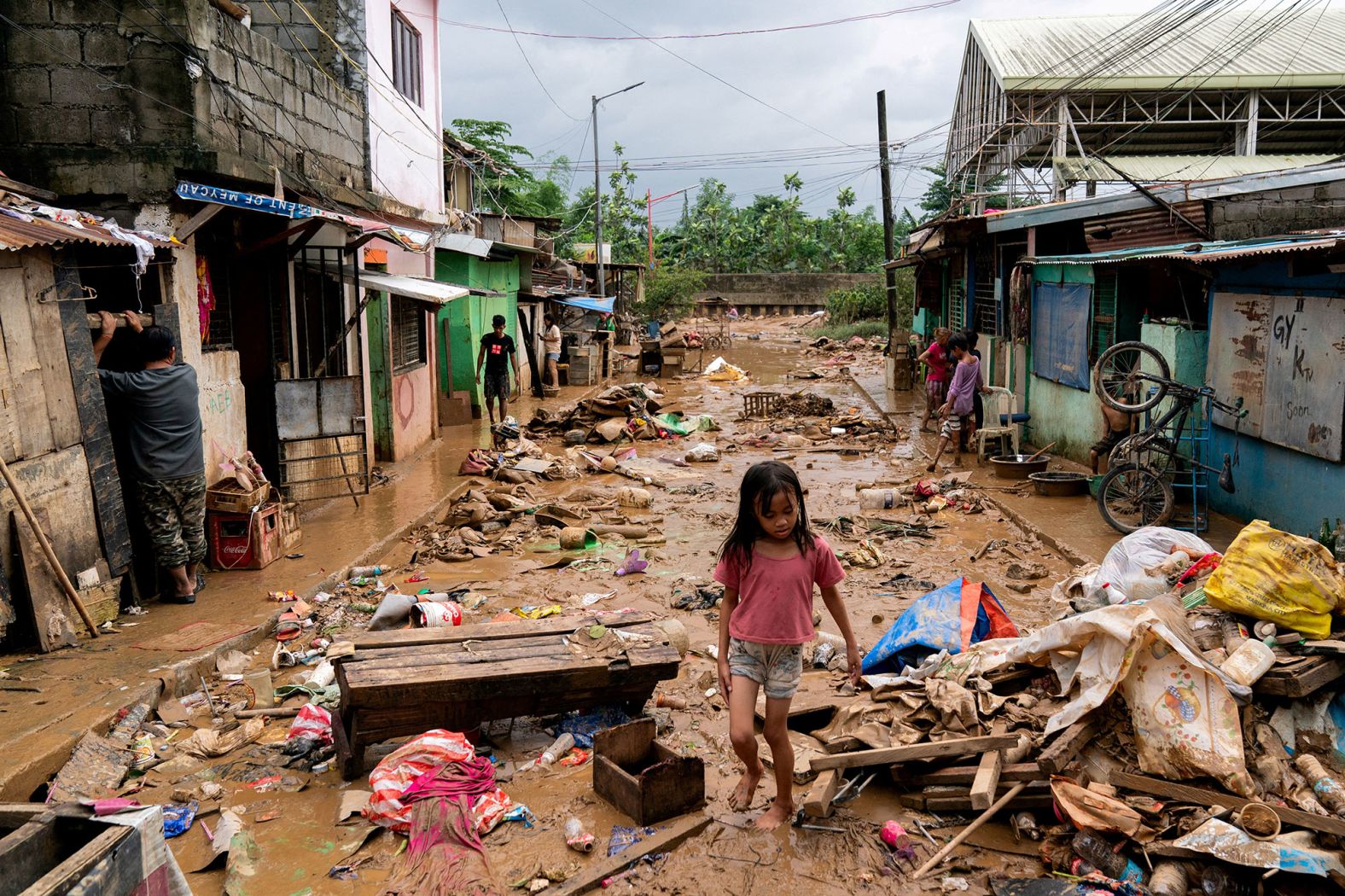 A girl walks past debris and mud in Marikina, Philippines, following flooding caused by <a href="index.php?page=&url=https%3A%2F%2Fwww.cnn.com%2F2024%2F07%2F25%2Fasia%2Fphilippines-flooding-manila-climate-typhoon-gaemi-intl-hnk%2Findex.html">Typhoon Gaemi</a> on Thursday, July 25.
