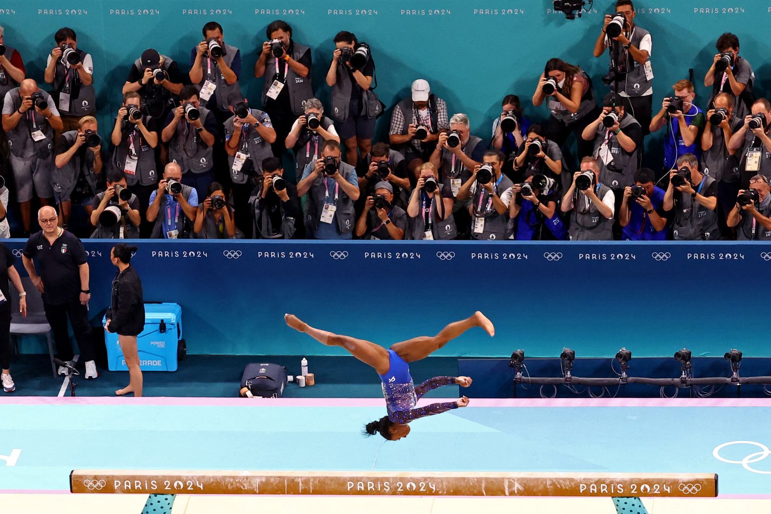 Photographers focus on Biles during her balance beam routine.