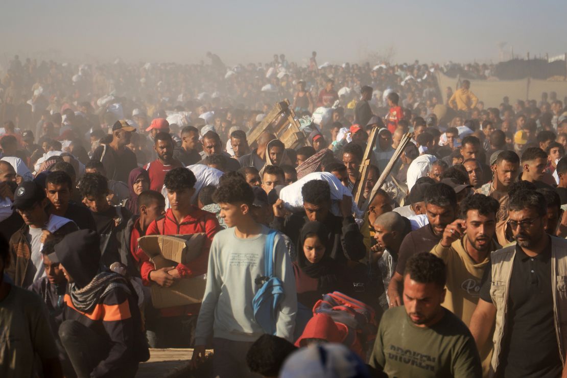 Palestinians carry boxes and bags containing food and humanitarian aid packages provided by the Gaza Humanitarian Foundation in Rafa, Gaza on May 29th.