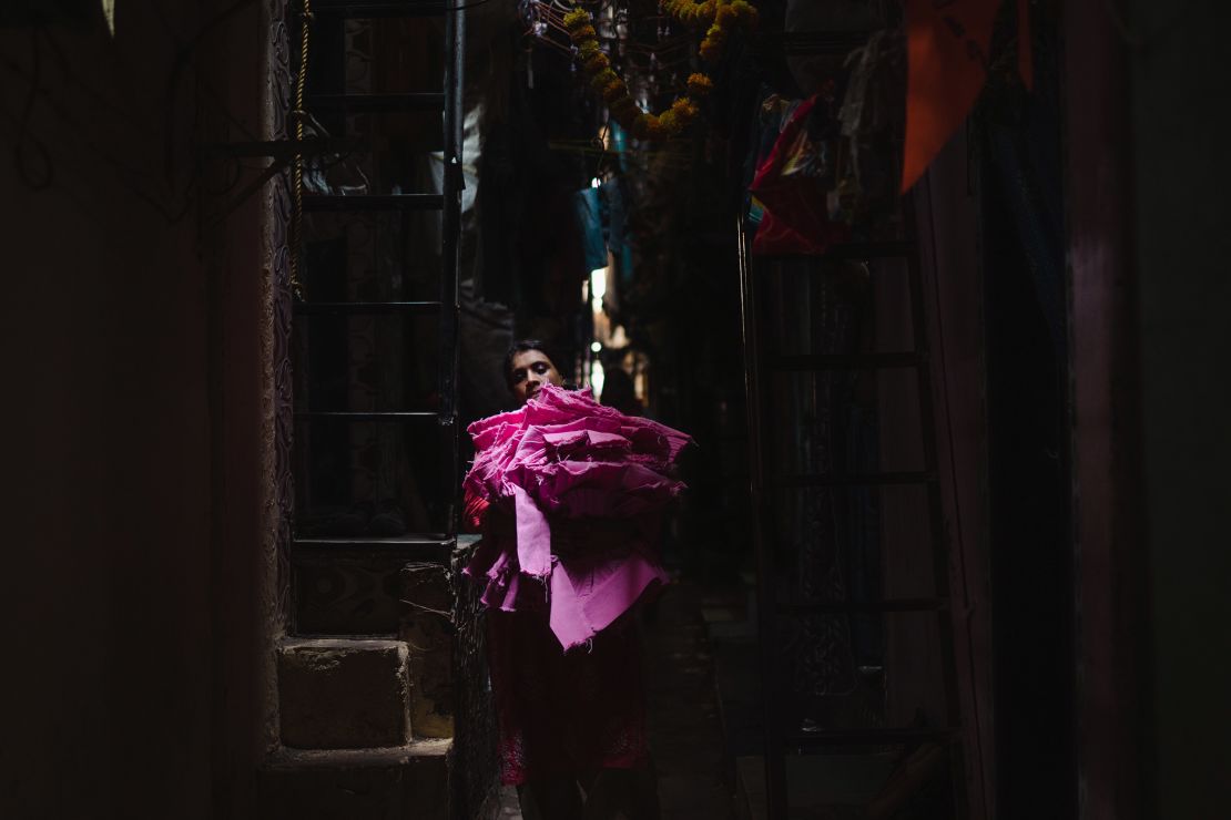 A woman carrying fabric walks along a narrow alley in Dharavi on April 14.
