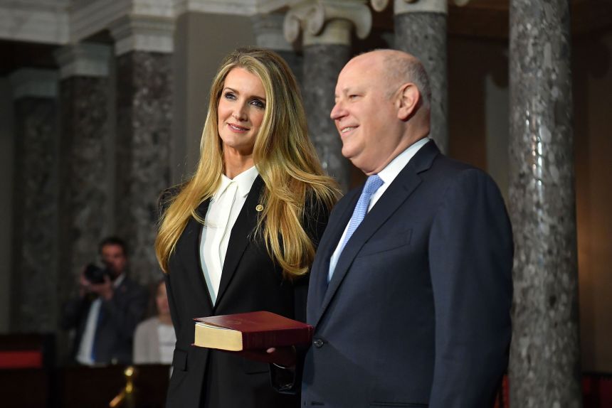 Sen. Kelly Loeffler and her husband Jeffrey Sprecher await her ceremonial swearing-in in 2019.