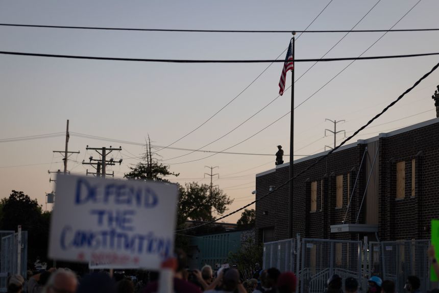 Federal law enforcement agents watch demonstrators outside of the Broadview ICE facility on September 27.