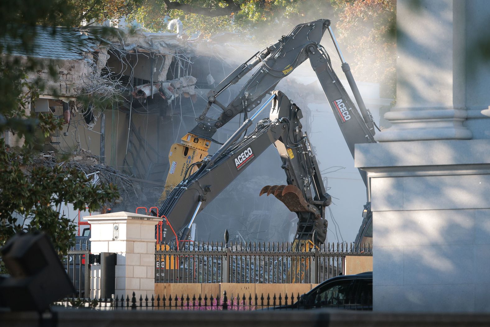 Workers use excavators to demolish the facade of the East Wing on October 20.