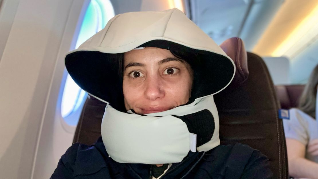 A photo of the author wearing the Pluto Pod Travel Pillow on an airplane