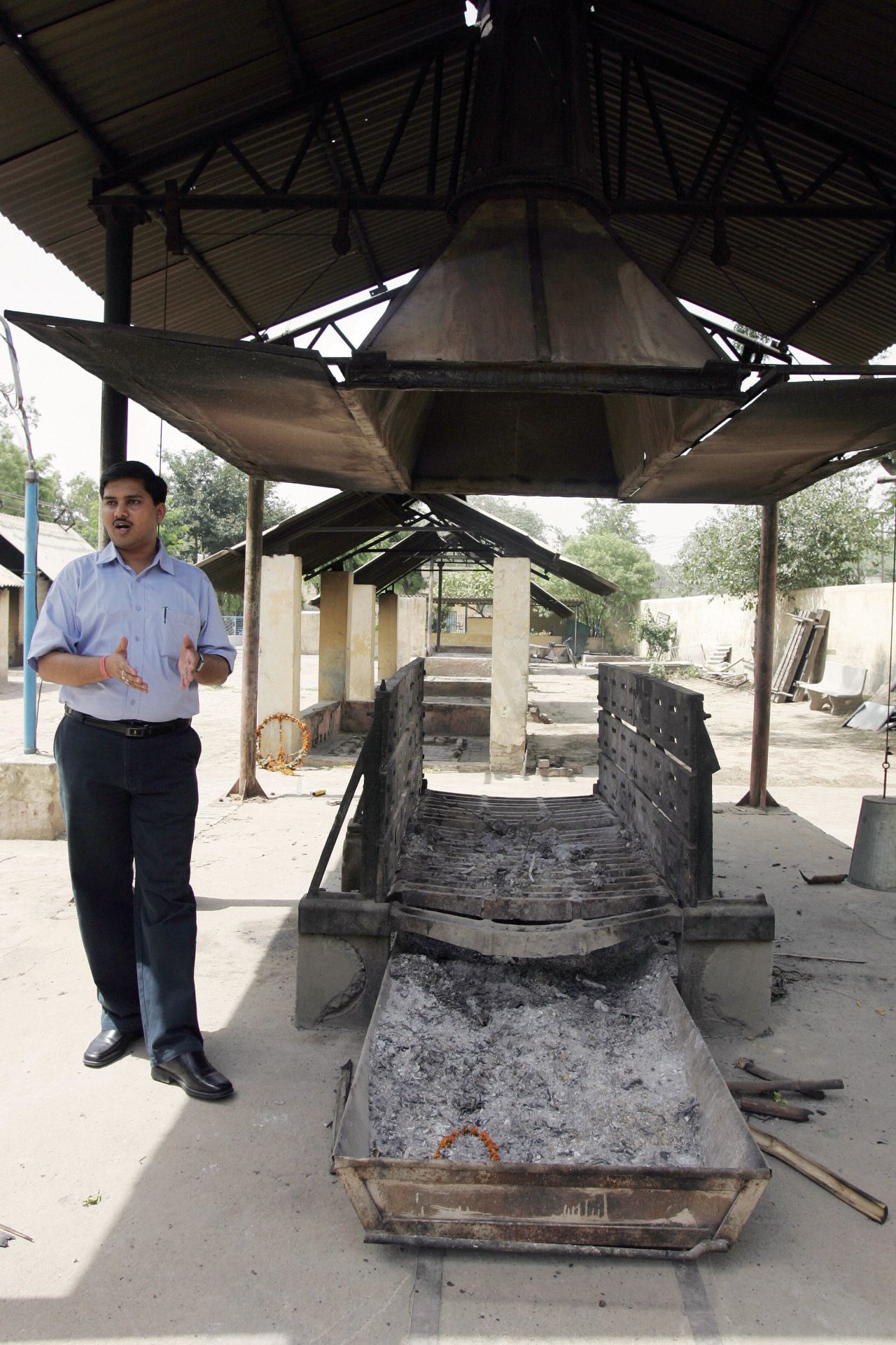 Anshul Garg, director of Mokshda, next to the group's "Green Cremation System." The NGO says its system reduces greenhouse gas emissions from burning wood by up to 60%.