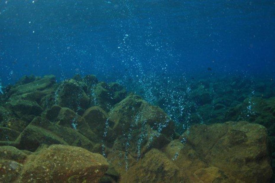 The submerged active volcano of Banua Wuhu in Indonesia seen releasing ribbons of silver bubbles of sulfur gas.