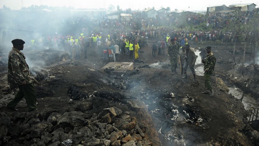 Uniformed police officers on September 12, 2011 secure the scene of a fire after the explosion of a fuel pipeline in a slum area in Nairobi. At least 120 people burned to death on September 12 when the pipeline burst into flames. A police commander said more than 100 people had been killed in the explosion at Nairobi's Lunga Lunga industrial area, which is surrounded by the densely packed tin-shack housing of the Sinai slum. 
