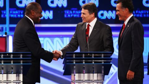 GOP presidential candidates Herman Cain, from left, Rick Perry and Mitt Romney chat after Monday's debate.