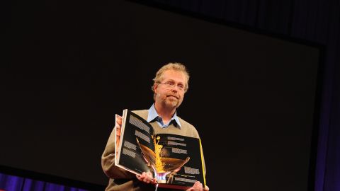 Nathan Myhrvold holds up his $625, 2,400-page book on the art and science of cooking, at TED2011 conference.