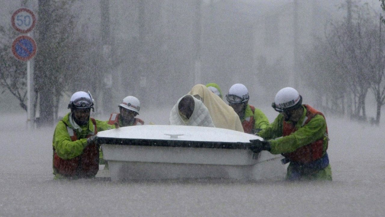 Rescue workers help evacuees through floodwaters in Nagoya.