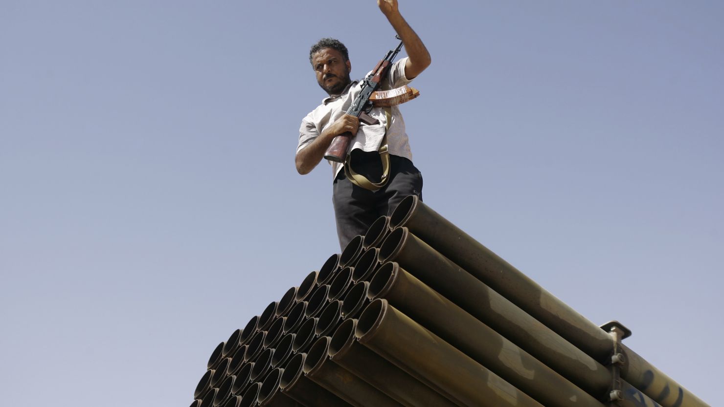 A Libyan NTC fighter poses for a photo on top of a Grad missile launcher on the outskirts of Bani Walid.
