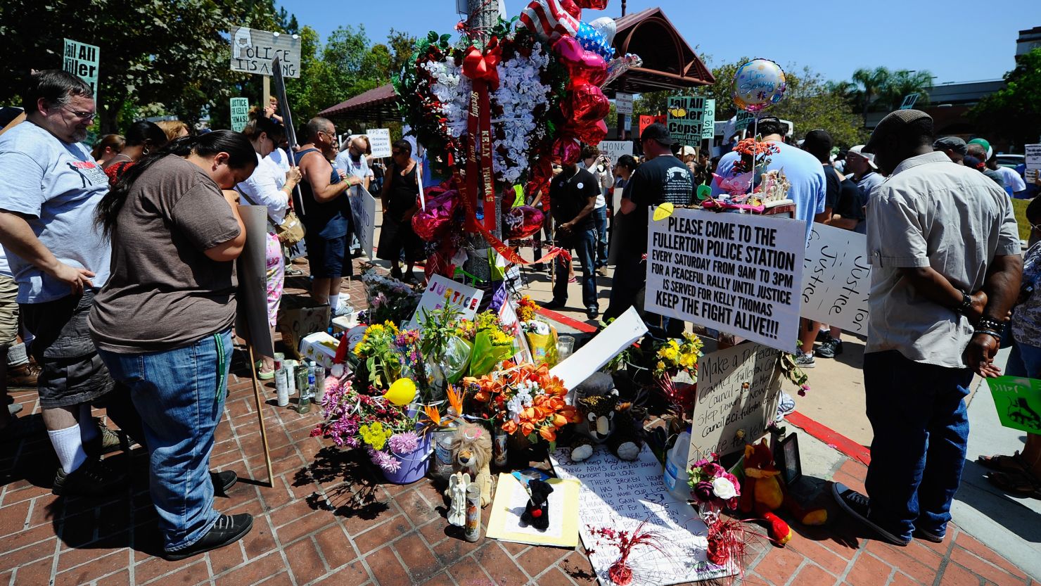  Demonstrators hold a moment of silence at a makeshift memorial for Kelly Thomas, a homeless man who died after an altercation with several officers, during a rally and protest march on August 20, 2011 in Fullerton, California. 