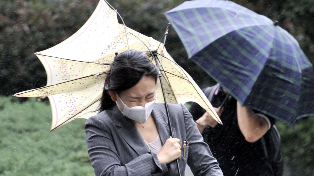 A woman braves strong winds as Typhoon Roke hits the Tokyo area.