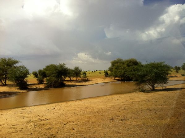 Robertson passes a muddy watering hole, filled by recent rain, along the journey.