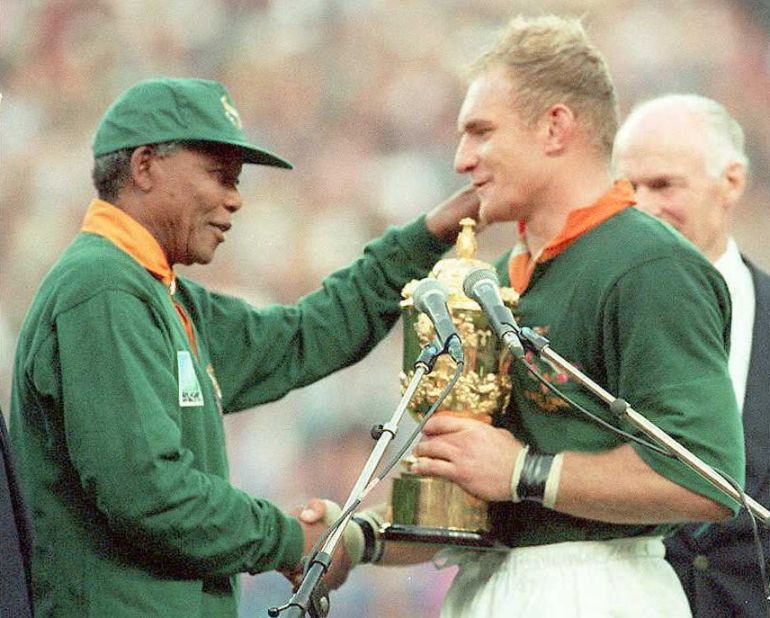 South Africa united in celebration after winning the Rugby World Cup on home soil in 1995. President Nelson Mandela, sporting the green and gold jersey of the Springboks, handed the Webb Ellis Cup to team captain Francois Pienaar.