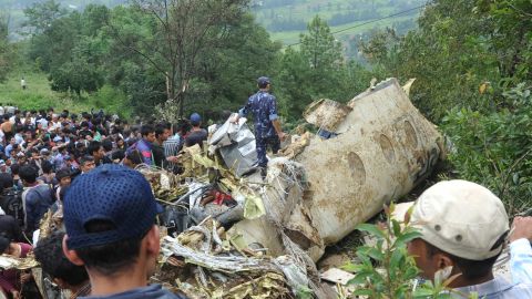 Onlookers and rescuers are seen near the wreckage of the aircraft in Lalitpur, on the outskirts of Kathmandu, on September 25.