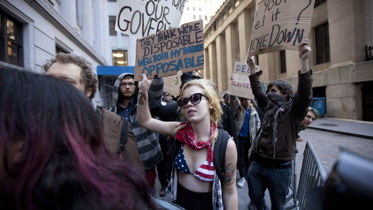 Protesters hold up signs during a demostration near Wall Street on Monday.