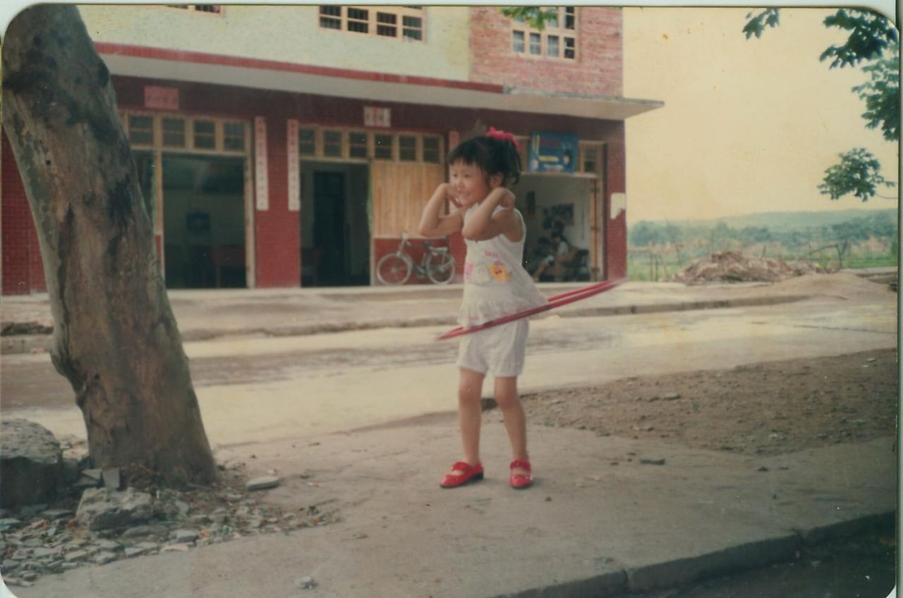 Hula hooping in the street outside her grandmothers house, aged 6. A long way from the runways of the world's fashion capitals.