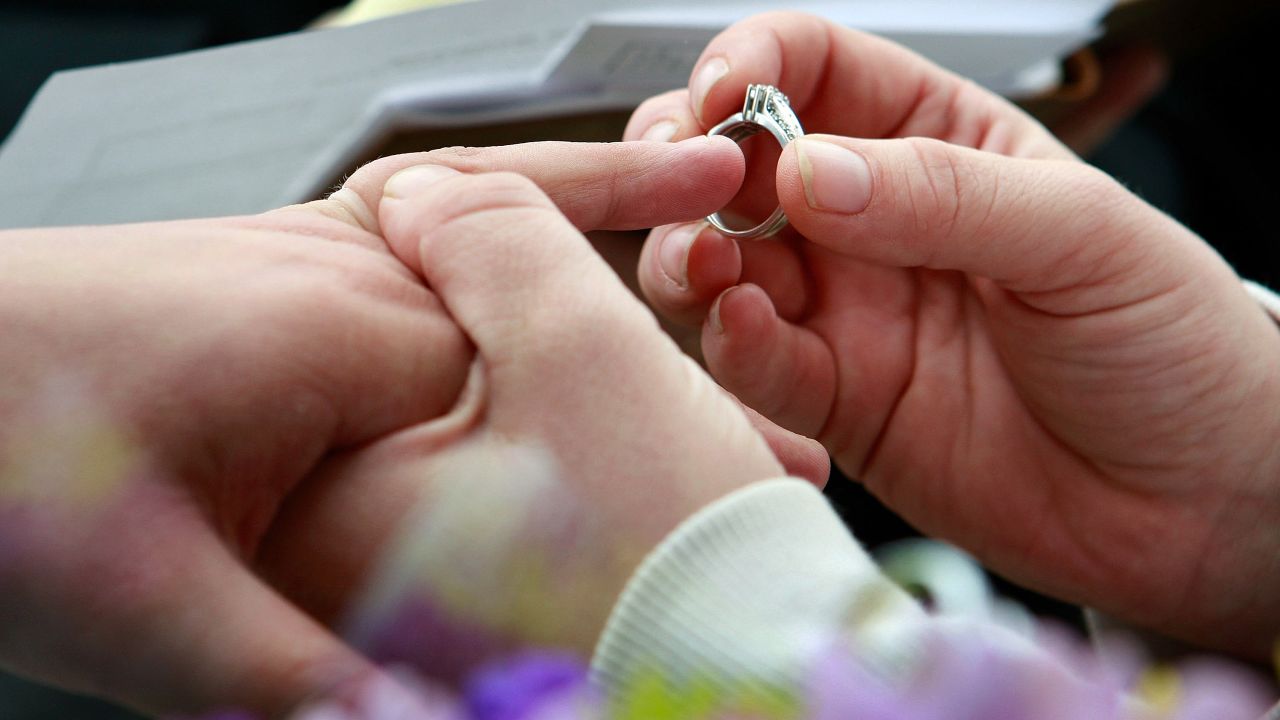 Jodie Vandermark-Martinez slides a ring on her partner, Jessica Vandermark-Martinez, during their wedding ceremony in Iowa.